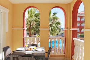 jadalnia ze stołem i balkonem z palmami w obiekcie Luxury apartment puerto marina los alcazares w mieście Los Alcázares