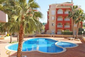 basen przed budynkiem z palmami w obiekcie Luxury apartment puerto marina los alcazares w mieście Los Alcázares