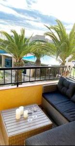 托雷維耶哈的住宿－Apartamento ESTRELLA con vistas a la piscina，阳台配有沙发和桌子,棕榈树