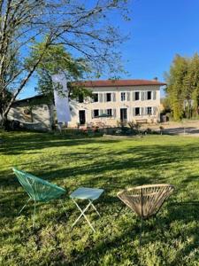 twee stoelen in het gras voor een huis bij La Chaise Haute in Hagetmau
