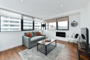 ein Wohnzimmer mit einem Sofa und einem Tisch in der Unterkunft Carlton Heights - A beautiful, inviting and modern 2 bedroom apartment, perfect for corporate stays and leisure in Nottingham