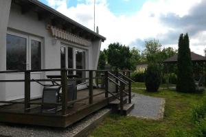 a house with a wooden deck next to a yard at Ferienhäuschen Hochufer in Lohme