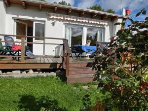 a house with a deck with a table and chairs at Ferienhäuschen Hochufer in Lohme