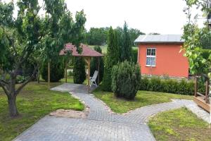 einen Garten mit einem Pavillon und einem roten Haus in der Unterkunft Lohme - Ferienhäuschen "Hochufer" ASM in Lohme