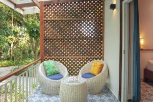 a patio with two wicker chairs and a fence at La Passion by Achariyak in Koh Rong Sanloem