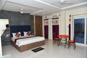 una camera con letto, tavolo e sedie di Hotel Lake View a Port Blair