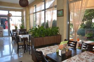 a restaurant with tables and chairs and windows at Семеен Хотел Детелини in Primorsko