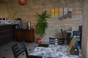 un comedor con mesa, sillas y una planta en Семеен Хотел Детелини en Primorsko