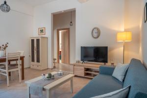 a living room with a blue couch and a tv at Stylish Central Renovated Apartment in Heraklio Town
