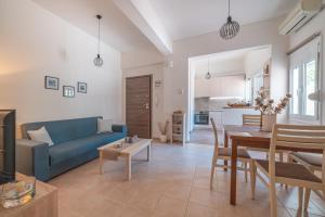Stylish Central Renovated Apartment في مدينة هيراكيلون: غرفة معيشة مع أريكة زرقاء وطاولة