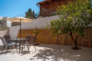 a table and chairs with an umbrella next to a fence at Stylish Central Renovated Apartment in Heraklio Town