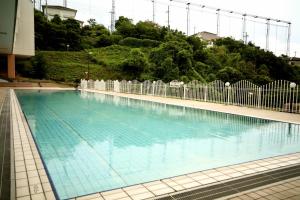 a large swimming pool with blue water at Hotel Tenzankaku Kaiyutei in Shirahama