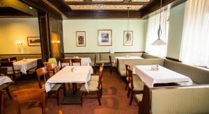 a dining room with white tables and chairs at Hotel Hadrigan in Vienna