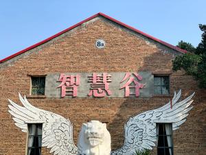 um edifício de tijolos com uma placa com duas asas brancas em Guilin Changshe Hotel em Guilin