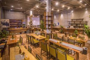 a restaurant with wooden tables and chairs and plants at Guilin Changshe Hotel in Guilin
