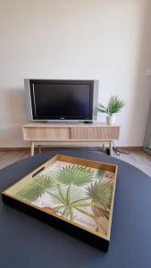 stół z tacą, na której znajduje się obrazek palm w obiekcie Magnifique Studio sur le Port de Gruissan (2 à 4 pers) w mieście Gruissan