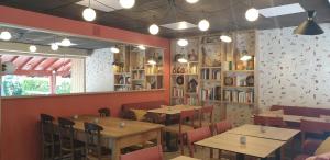 a restaurant with tables and chairs and books on the wall at Camping ZELAIA in Ascain