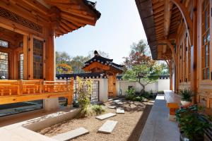 a courtyard of a home with a wooden building at IRIRU Luxury Hanok Stay - Eunpyung Hanok village in Seoul
