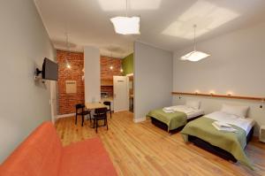 a room with two beds and a table and a couch at Good Time Aparthotel in Łódź