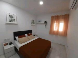 a small bedroom with a bed and a window at Casa Playa Caleta, a 4 minutos de la playa in Cádiz