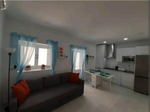 a living room with a couch and a kitchen at Casa Playa Caleta, a 4 minutos de la playa in Cádiz