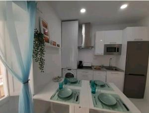 a kitchen with a table with green plates on it at Casa Playa Caleta, a 4 minutos de la playa in Cádiz +14 photos