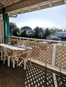 einen Tisch und Stühle auf einem Balkon mit einem Zaun in der Unterkunft Joli duplex ensoleillé in Capbreton