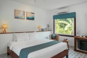 a bedroom with a bed and a window at La Passion by Achariyak in Koh Rong Sanloem