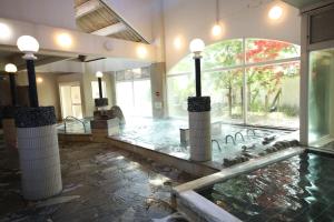 Habitación grande con piscina de agua en un edificio en Tennenonsen Amuri en Amakusa