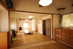 una habitación con un pasillo con una mesa y una habitación sin intención en Tennenonsen Amuri en Amakusa