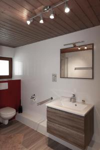 ein Badezimmer mit einem Waschbecken, einem WC und einem Spiegel in der Unterkunft Hotel Neuwirt in Mieming