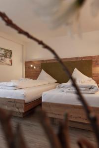 A bed or beds in a room at Hotel Neuwirt