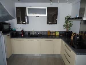 a kitchen with white cabinets and black counter tops at Maison entre Loire et châteaux in Menars +18 photos