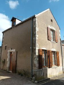 an old building with boarded up windows on a street at Maison entre Loire et châteaux in Menars