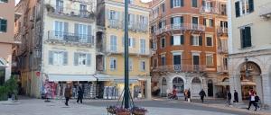 a city street with buildings and a pole with flowers at Studio CASINELLA in Corfu