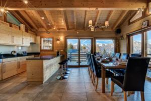 a dining room with a table and chairs and mountains at Chalet le Cerf in La Tzoumaz