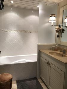 a bathroom with a bath tub and a sink at Studio les pieds dans l'eau in Duingt