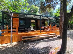 ein Haus mit einer abgeschirmten Veranda mit einem TV in der Unterkunft Mobile Homes Camping Biograd in Biograd na Moru