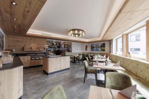 a restaurant with tables and chairs and a kitchen at Hotel Neuwirt in Mieming