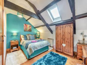 a bedroom with a bed with blue walls and a window at Ty Llaethdy - Oac in Gowerton