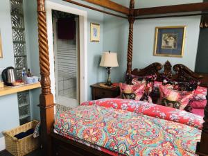 a bedroom with a large bed with a red comforter at The Forester and Flower in Bath