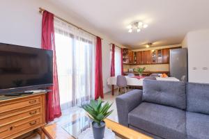 a living room with a couch and a flat screen tv at Apartment Dino 1 in Mali Lošinj