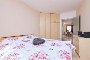 Un dormitorio con una cama con flores rosas. en Apartment Dino 1 en Mali Lošinj