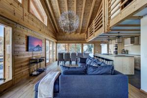 a living room with a blue couch and wooden walls at Chalet la Chance in La Tzoumaz