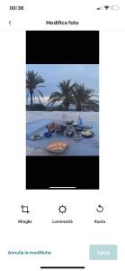 a television screen showing a dinner table on the beach at Intero Dammuso Pantesco in Pantelleria