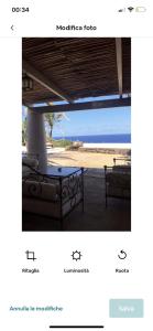 a view of a beach with two chairs and a table at Intero Dammuso Pantesco in Pantelleria