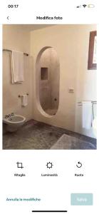 La salle de bains est pourvue d'un miroir, d'un lavabo et de toilettes. dans l'établissement Intero Dammuso Pantesco, à Pantelleria