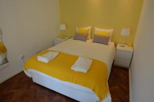 リスボンにある4U Lisbon II Guesthouseのベッドルーム1室(大型ベッド1台、黄色いシーツ、枕付)