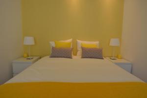 a bedroom with a large bed with two night stands at 4U Lisbon II Guesthouse in Lisbon