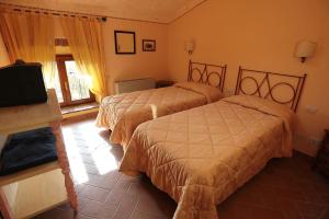 a hotel room with two beds and a television at Poggio Agli Ulivi in Barberino di Mugello